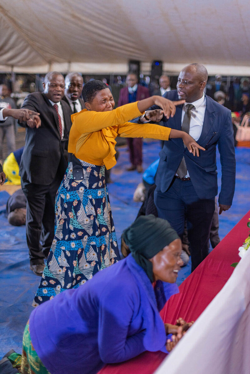 Woman testifying with outstretched arms